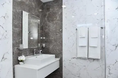 a white bathroom with a sink and a mirror at Kaleya House in Chernomorets