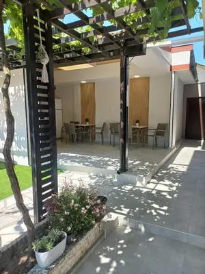 a pergola with tables and chairs and plants at Kaleya House in Chernomorets