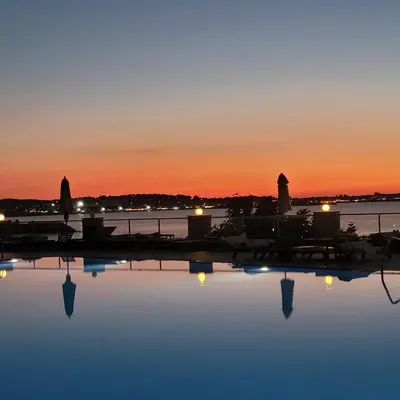 a pool of water with a sunset in the background at Sozopolis Sunset Apartment with sea view in Sozopol