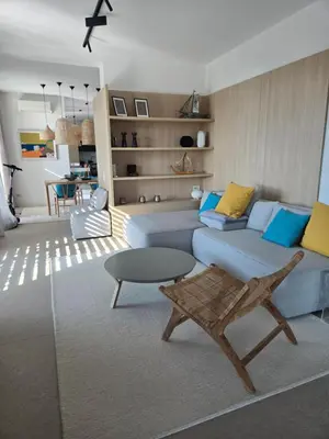 a living room with a blue couch and a table at Sozopolis Sunset Apartment with sea view in Sozopol