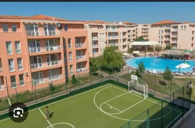 a tennis court in front of some apartment buildings at Sunny Day 6 in Sunny Beach