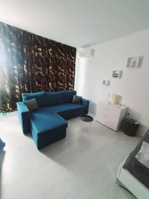 a living room with a blue couch in front of a wall at Sunny Day 6 in Sunny Beach