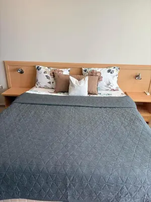 a bed with a blue comforter and pillows at Miramar Palace 615 in Sunny Beach