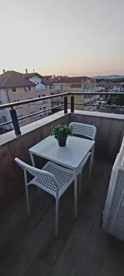 a white table and chairs on a balcony with a plant at Апартамент ReLax Китен in Kiten