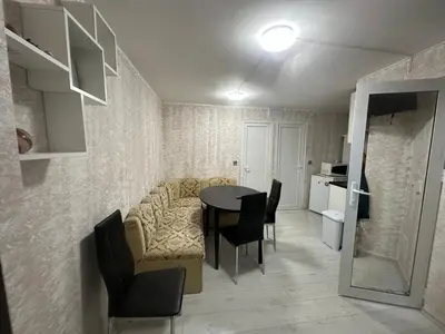 a living room with a couch and a table and chairs at Rumen Apartment in Nesebar