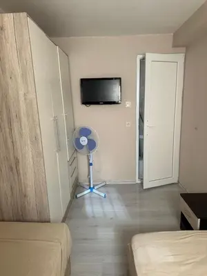 a bedroom with a room with a fan and a tv at Rumen Apartment in Nesebar