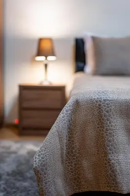 a bedroom with a bed with a table with a lamp at Top Location 3 Bedroom Apartment Next to the Beach in Varna City