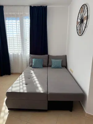 a bed in a room with a clock on the wall at BW - Happy 67 in Sunny Beach