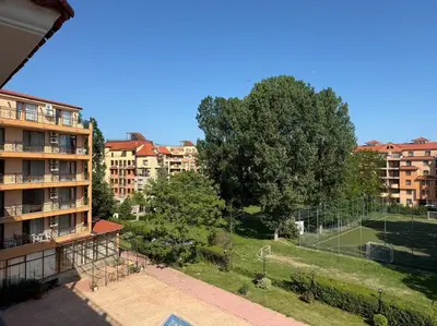 an apartment building with a tennis court in a park at BW - Happy 67 in Sunny Beach