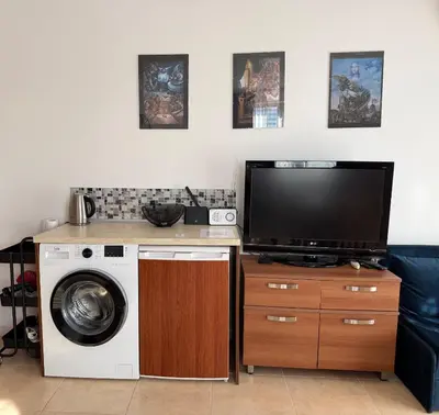 a living room with a tv and a washing machine at BW - Happy 67 in Sunny Beach