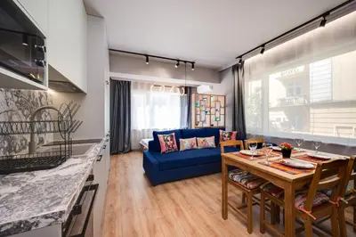 a kitchen and living room with a table and a blue couch at Top Central Flats with Style in Varna City