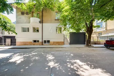 an empty street in front of a building with a tree at Top Central Flats with Style in Varna City