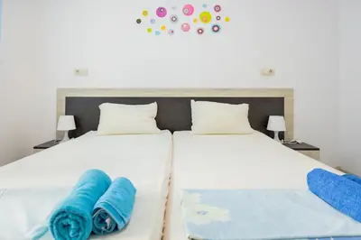 two beds in a bedroom with blue towels on them at Marea 1 in Pomorie