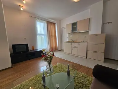 a living room with a table and a kitchen at Odisei Large Studio in Nesebar
