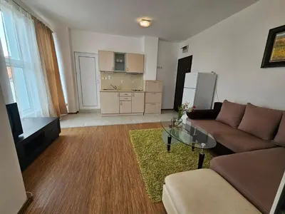 a living room with a couch and a kitchen at Odisei Large Studio in Nesebar