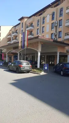 a large building with cars parked in a parking lot at Royal Sun Apartment in Sunny Beach