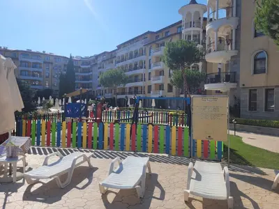 a colorful fence with chairs in front of a building at Royal Sun Apartment in Sunny Beach