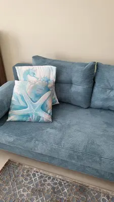 a blue couch with a starfish pillow on it at Делукс апартамент -Тюркоазен релакс in Pomorie