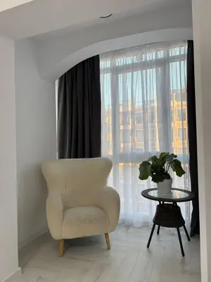 a living room with a chair and a table and a window at Sveti Vlas, Rodopi Bay Residence in Sveti Vlas