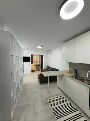 a kitchen with white cabinets and a living room at Sveti Vlas, Rodopi Bay Residence in Sveti Vlas
