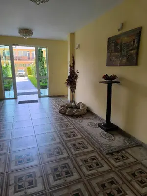 a room with a tile floor and a table with flowers on it at Golden Hermes, Studio z basenem in Sunny Beach