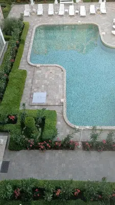 an overhead view of a swimming pool with chairs and flowers at Golden Hermes, Studio z basenem in Sunny Beach