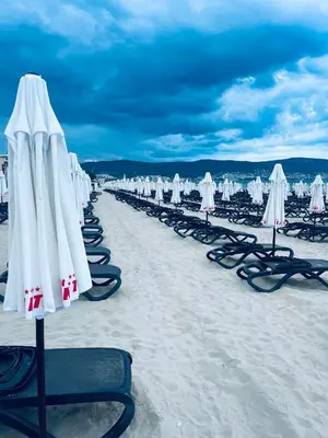 a row of beach umbrellas on the beach at Rose Garden Apartment 10 in Sunny Beach