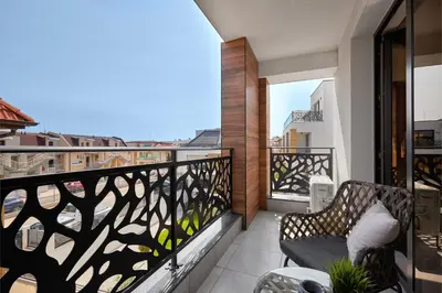 a balcony with a chair and a view of the city at SEA SHELL Apartment in Sozopol