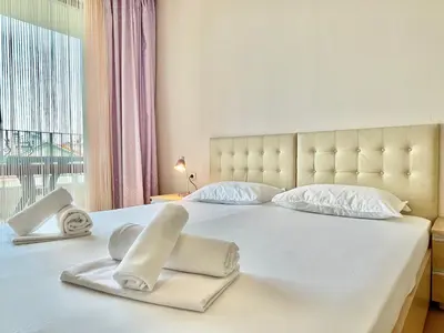 a white bed with two folded towels on it at Prestige Fort Aparthotel - Private apartment - BSR - 3 in Sveti Vlas