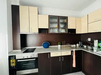 a kitchen with wooden cabinets and stainless steel appliances at AQUA BLUE APARTMENTS 38 Penthouse Sunny Beach in Sunny Beach