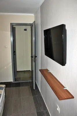 a room with a television on a wall with a hallway at Иглика Апарт Несебър in Nesebar