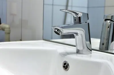 a bathroom sink with a faucet and a mirror at Иглика Апарт Несебър in Nesebar