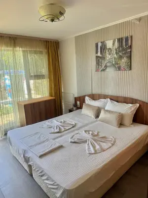 a bedroom with a large bed with towels on it at Иглика Апарт Несебър in Nesebar