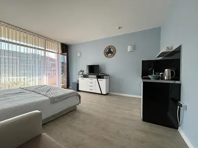 a bedroom with a bed and a tv and a kitchen at BW - Studio Grenada 316B in Sunny Beach