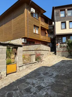 a house with a balcony and a stone driveway at Guest House Amfora with a sea view in Sozopol