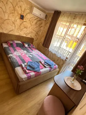 a small bedroom with a bed and a table at Guest House Amfora with a sea view in Sozopol