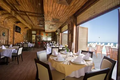 a restaurant with white tables and chairs and a large window at Appart complex - Egrek 3 in Lozenets