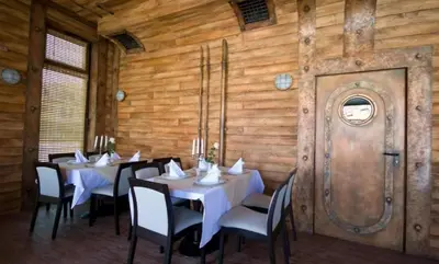 a dining room with tables and chairs and a wooden wall at Appart complex - Egrek 3 in Lozenets