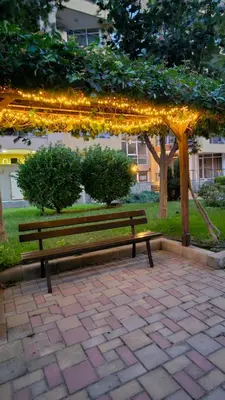 a park bench sitting under a string of lights at Boho Breeze Aheloy in Aheloy