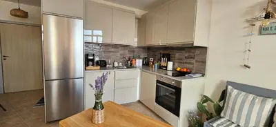 a kitchen with white cabinets and a stainless steel refrigerator at Boho Breeze Aheloy in Aheloy