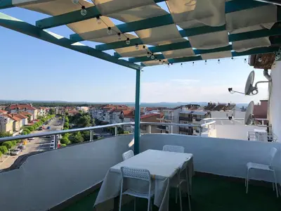 a table on a balcony with a view of a city at Apartment Terrace under the stars in Primorsko