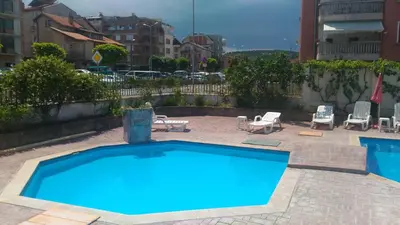 a large blue swimming pool with two chairs and a patio at Apartment Terrace under the stars in Primorsko