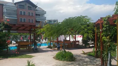 a resort with a pool and palm trees and a building at Apartment Terrace under the stars in Primorsko