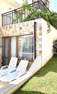 a group of white lounge chairs on a patio at Apartments in Villas Apolon in Sozopol