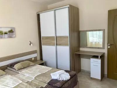 a small bedroom with a bed and a mirror at Apartments in Villas Apolon in Sozopol