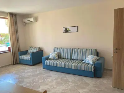 a living room with a couch and a chair at Apartments in Villas Apolon in Sozopol