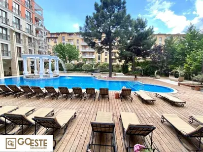a large pool with chairs and a gazebo at Patrick's apartments - Harmony Palace in Sunny Beach