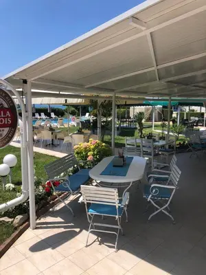 a patio with a table and chairs under a pavilion at Relax in Riviera in Sveti Vlas