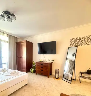 a bedroom with a bed and a television on the wall at Marena Studio - Santa Marina, Sozopol in Sozopol