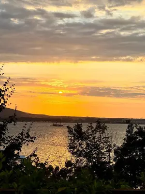 a sunset over a lake with a boat in the water at Marena Studio - Santa Marina, Sozopol in Sozopol